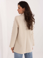 Jasnobeżowa marynarka z zapięciem na guzik