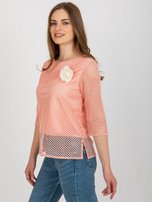 Peach Wholesale blouse with a flower.