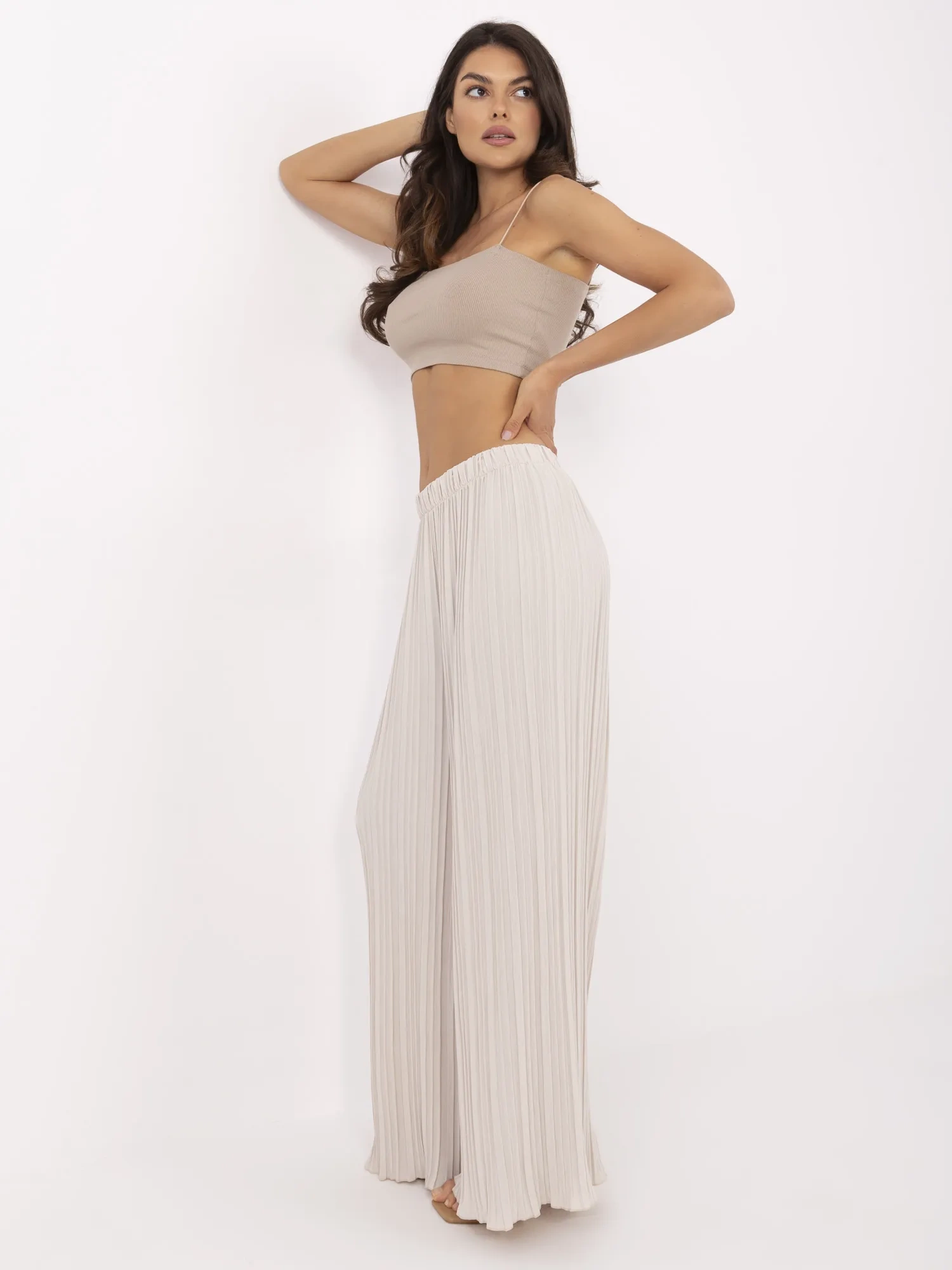 Beige wide trousers made of textured fabric.