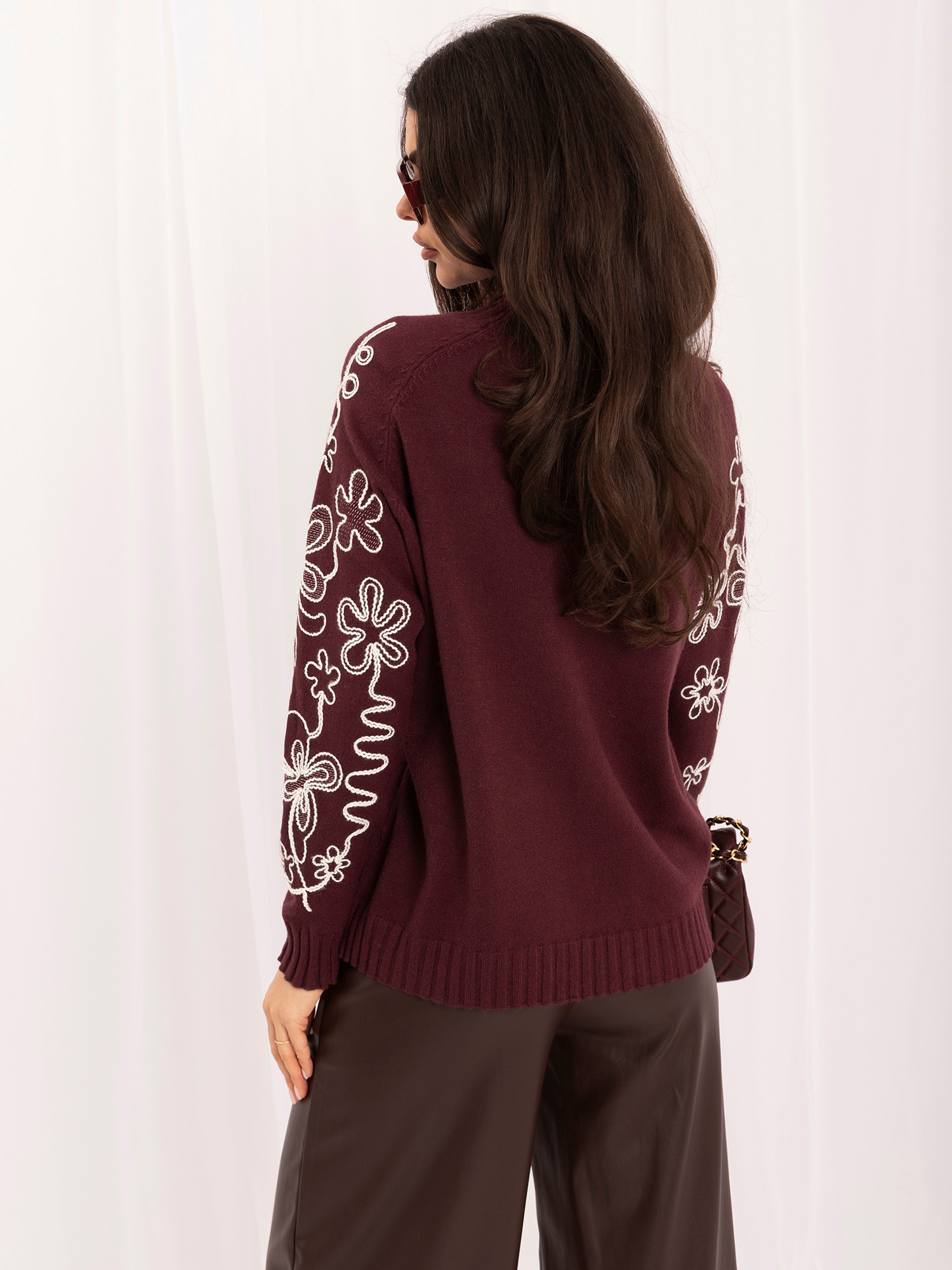 Bordeauxfarbener Pullover mit bestickten Ärmeln in Blumenmuster.