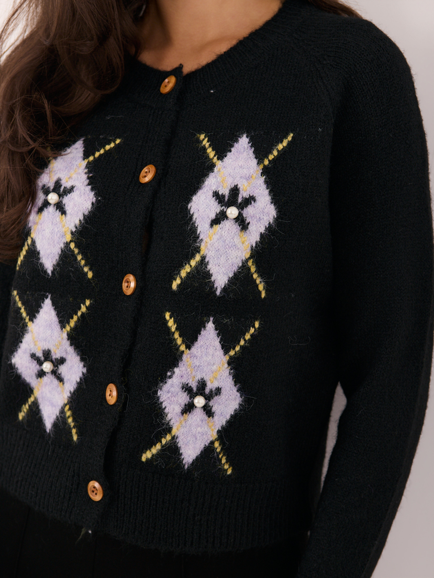 Black zip-up sweater with appliqués.