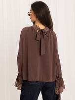 Dunkelbeige Bluse mit Schleife auf dem Rücken.