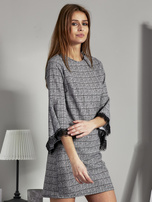Schwarz-weiße gemusterte Kleid mit spanischen Ärmeln.