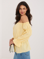 Jasnožuta muslinasta bluza s gumicom u struku.