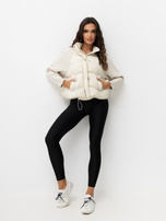 Helle beige Daunenjacke mit Strickärmeln.