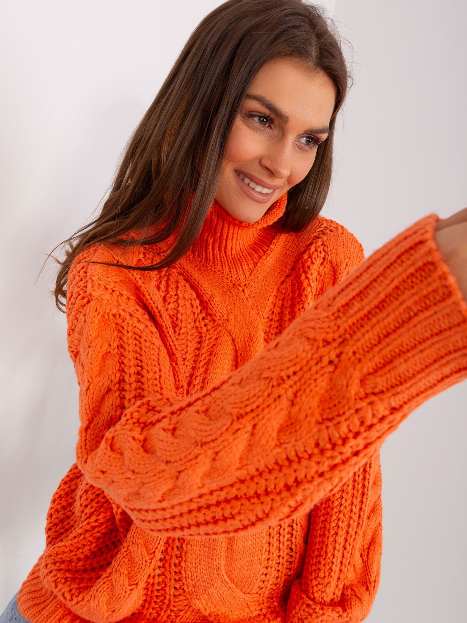 Pomarańczowy sweter oversize z warkoczami