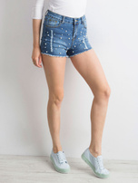 Blaue Jeansshorts mit Perlen und Rissen.
