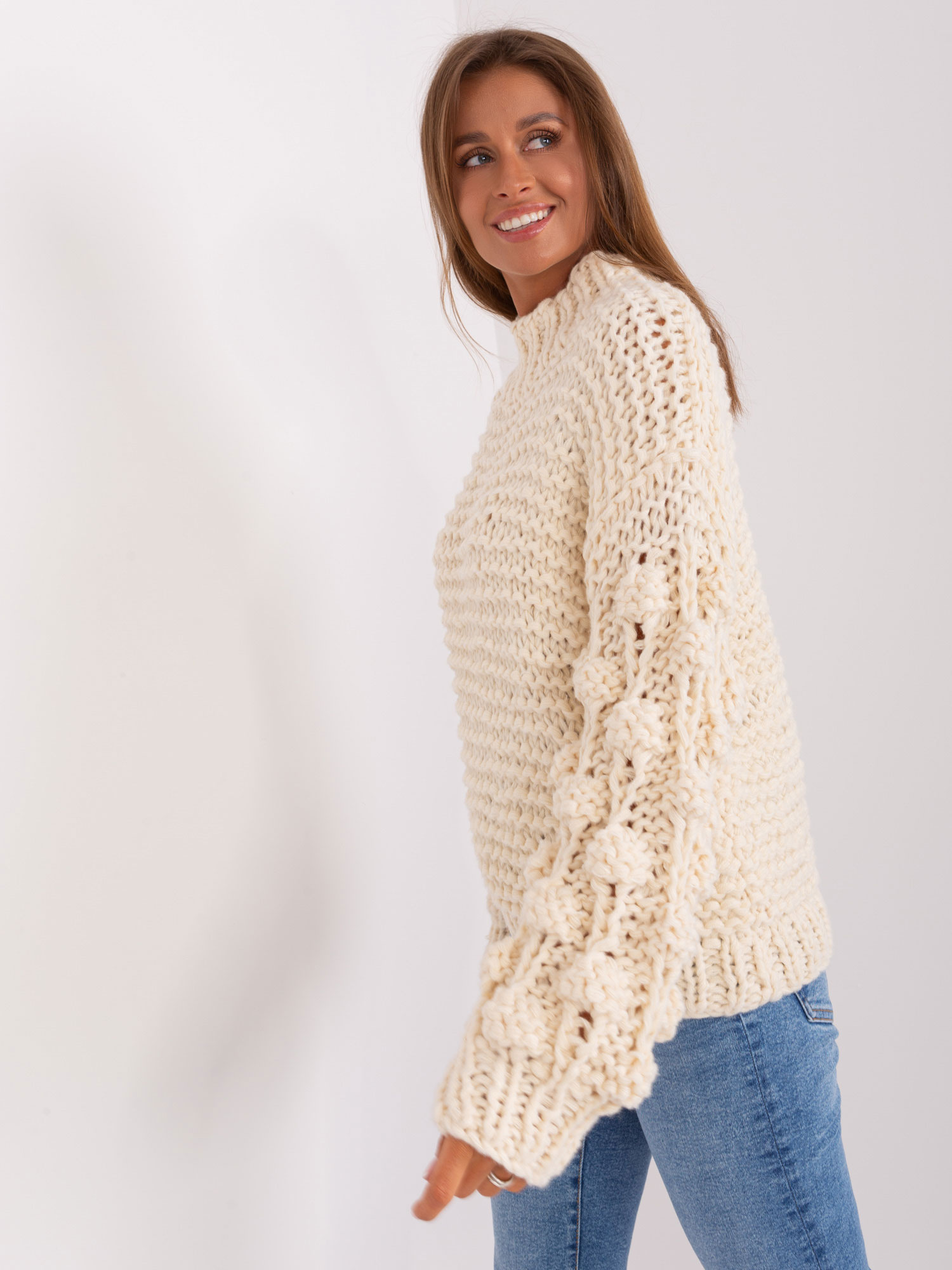 Jasnobeżowy sweter oversize z grubym splotem