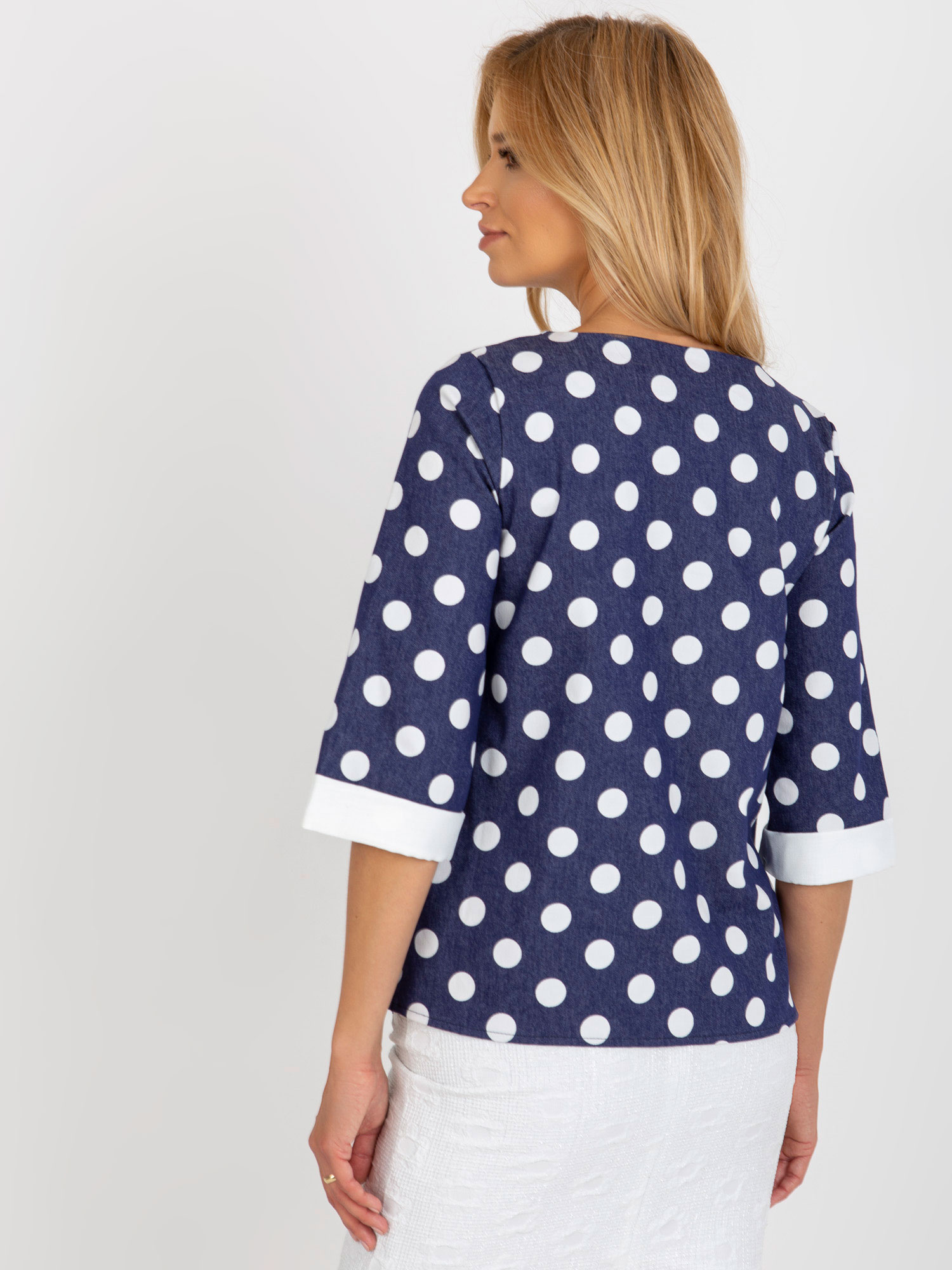Dunkelblaue Bluse mit Punkten und 3/4-Ärmeln.