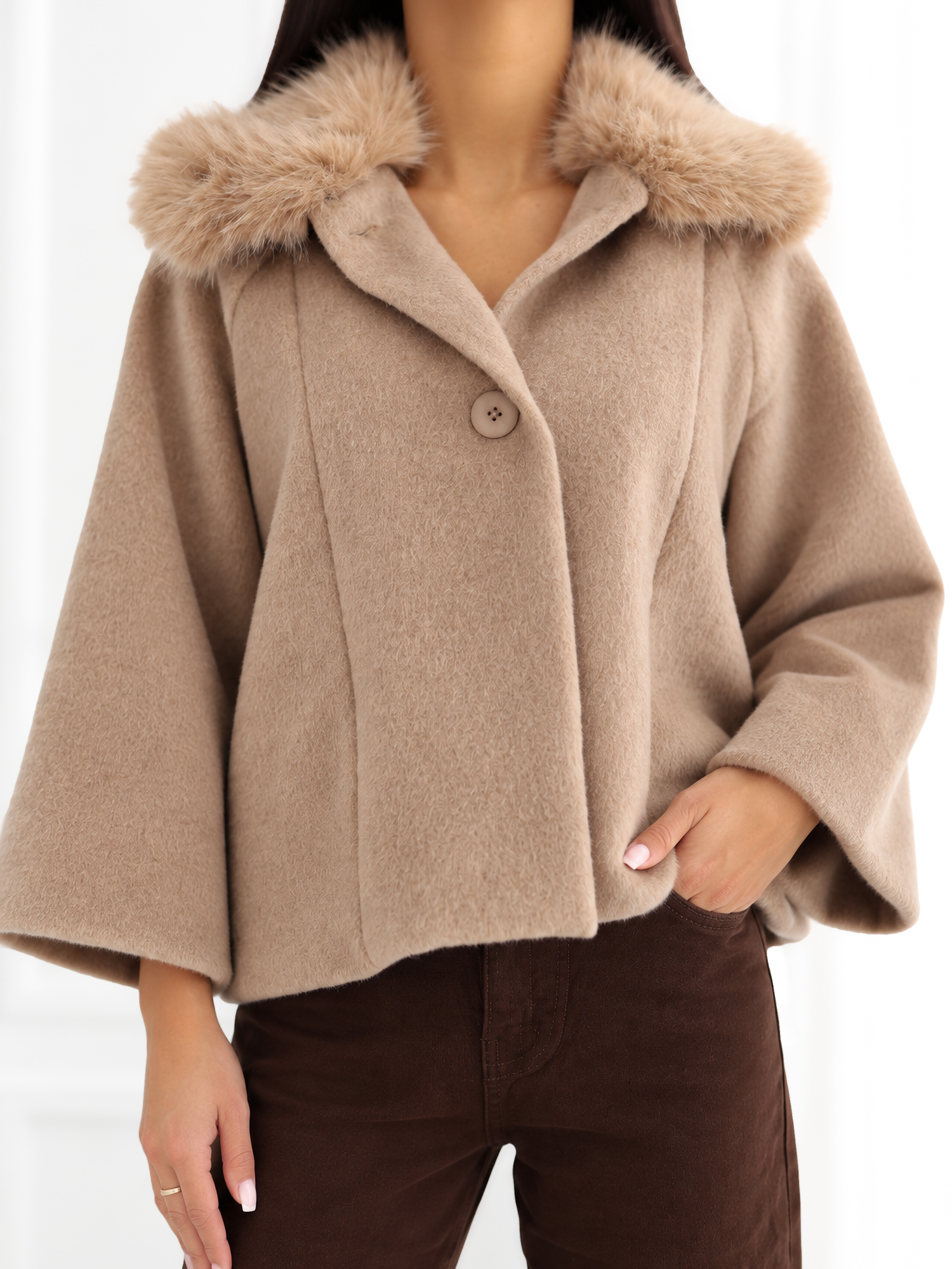 Beige trapezförmiger Mantel mit Knopfverschluss.