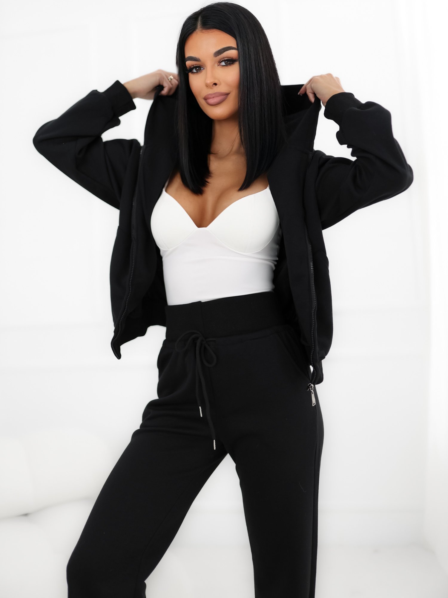 Schwarzes zweiteiliges Basic-Set mit einer offenen Jacke.