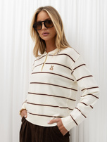 Helle beige Damen-Polo mit langen Ärmeln.