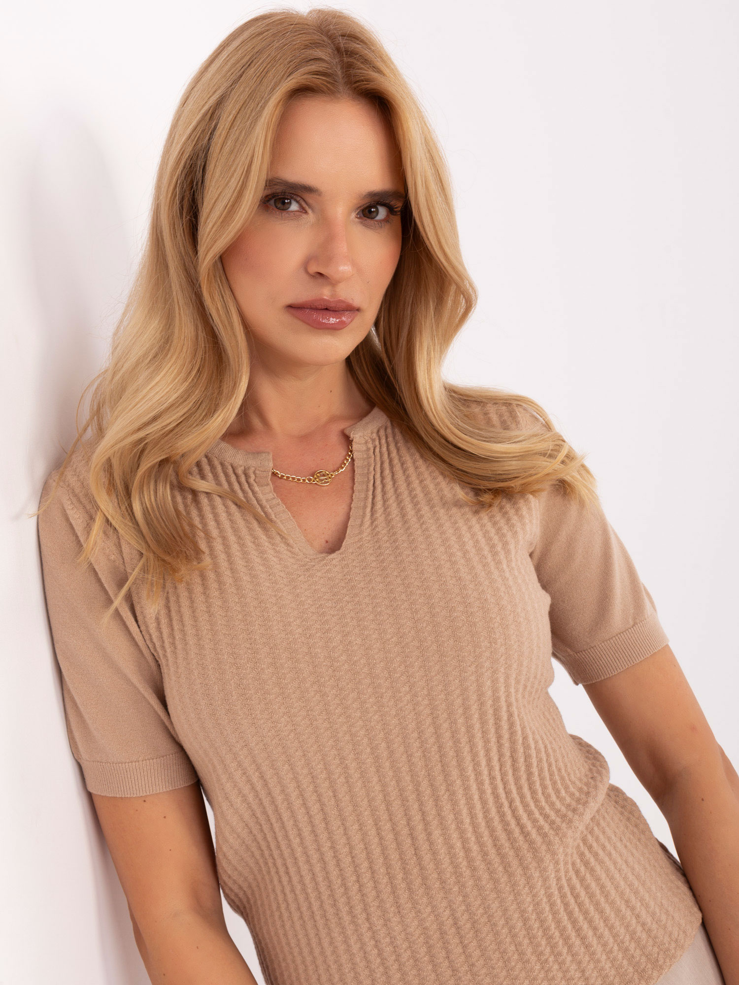 Camel sweater with decorative chain.