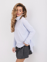 Světle modrý oversized svetr s delším zadním dílem.