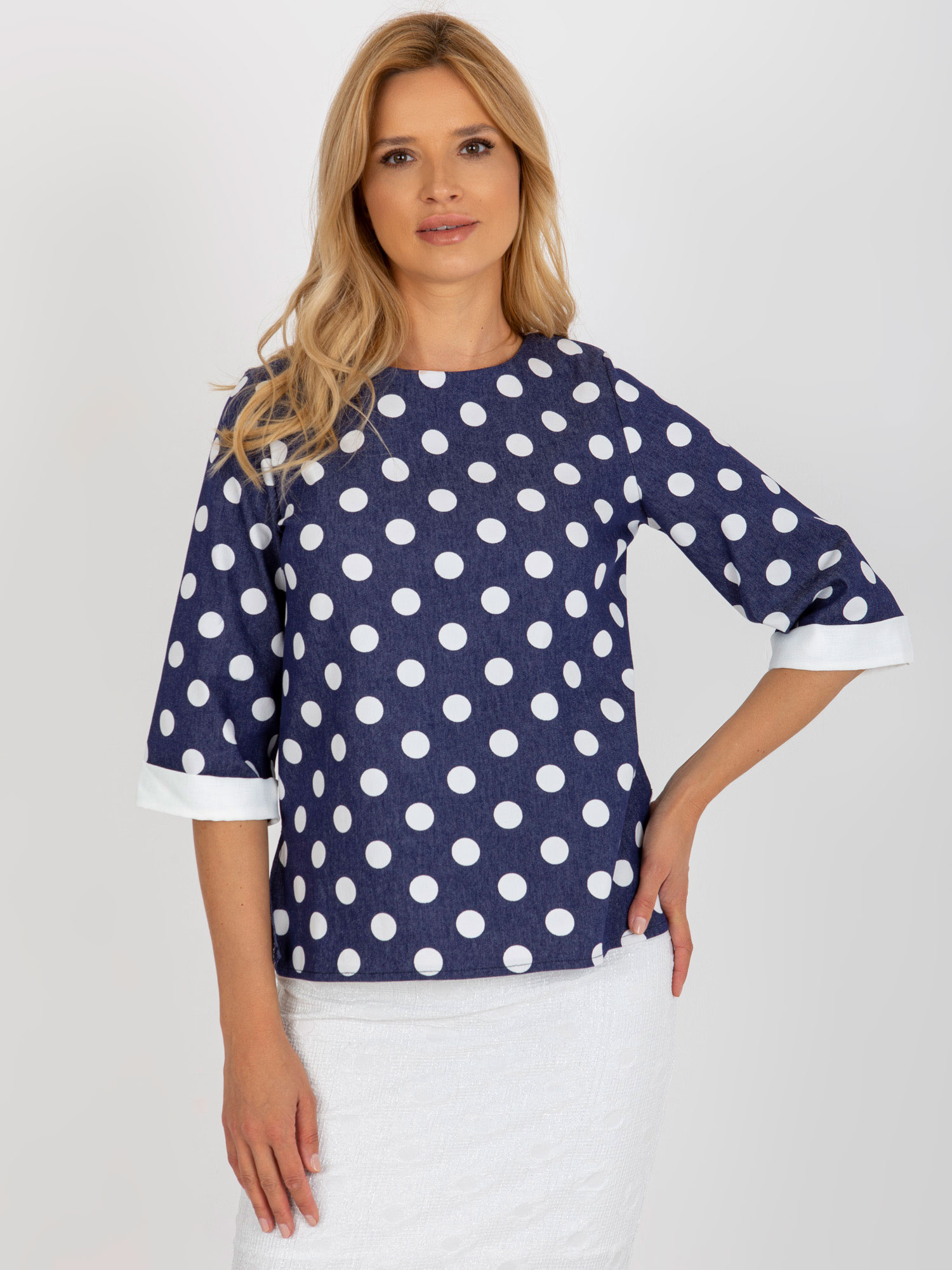Dunkelblaue Bluse mit Punkten und 3/4-Ärmeln.