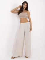 Beige wide trousers made of textured fabric.