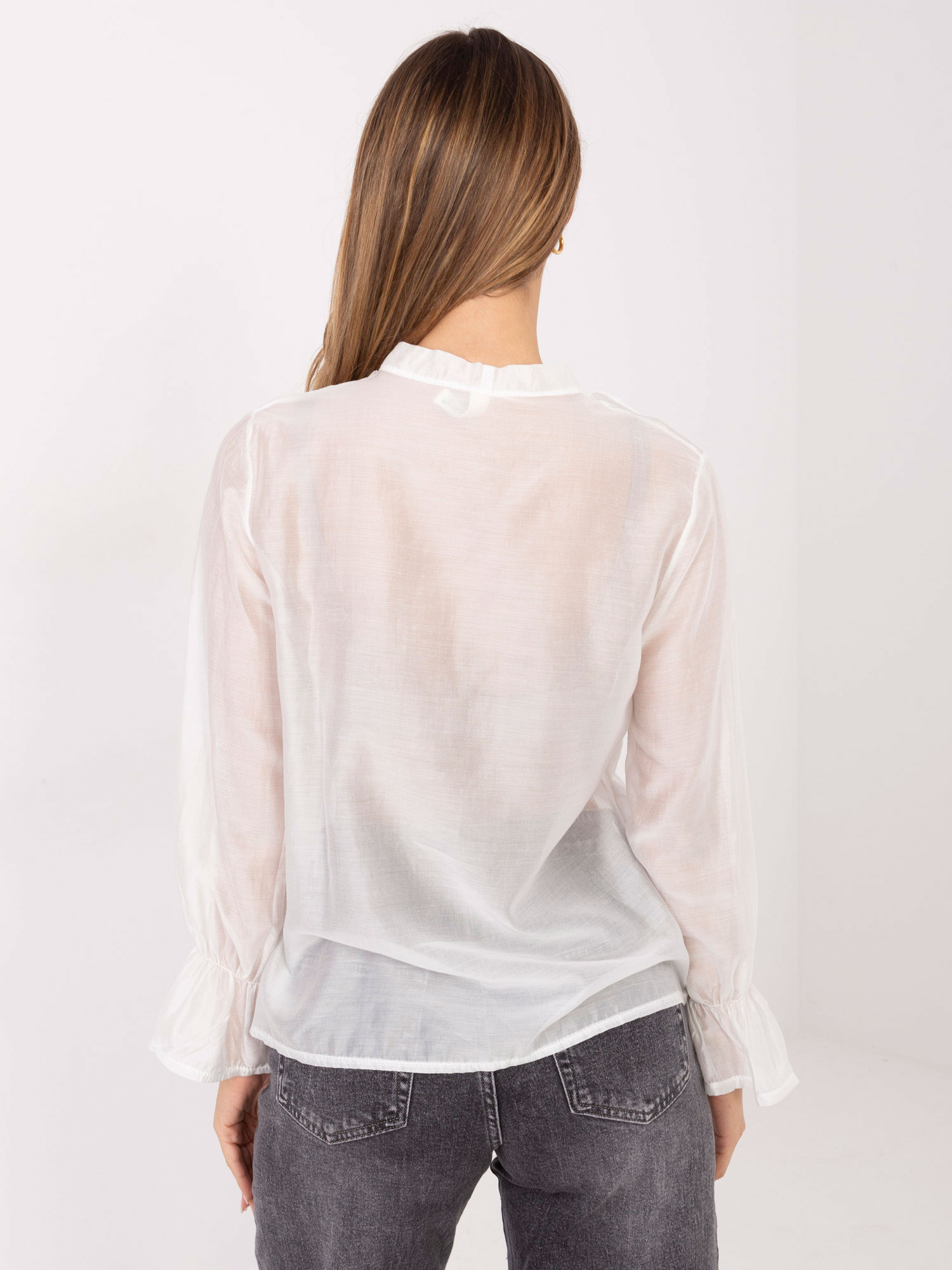 Weiße durchsichtige Bluse mit Rüschen.