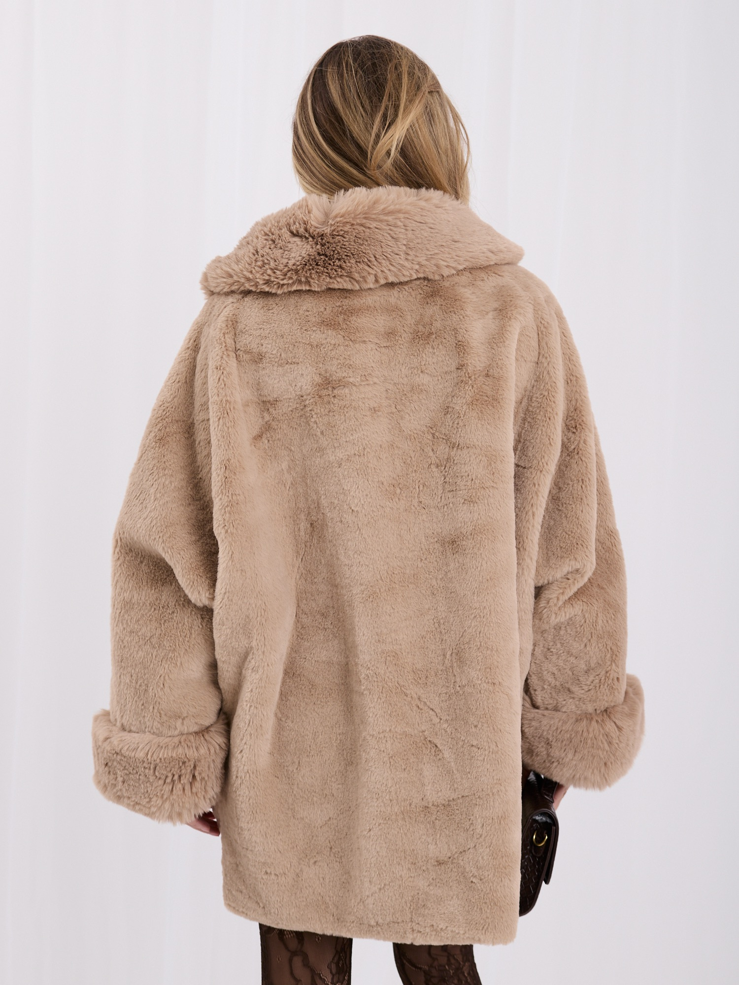 Beige women's fur coat with impressive sleeves.