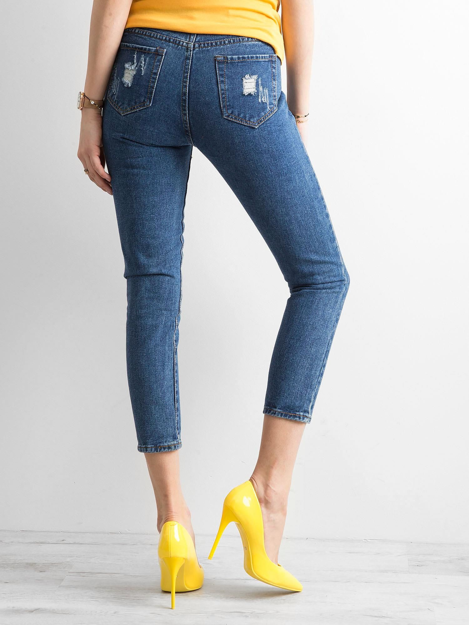 Dunkelblaue Ankle Jeans mit Rissen.