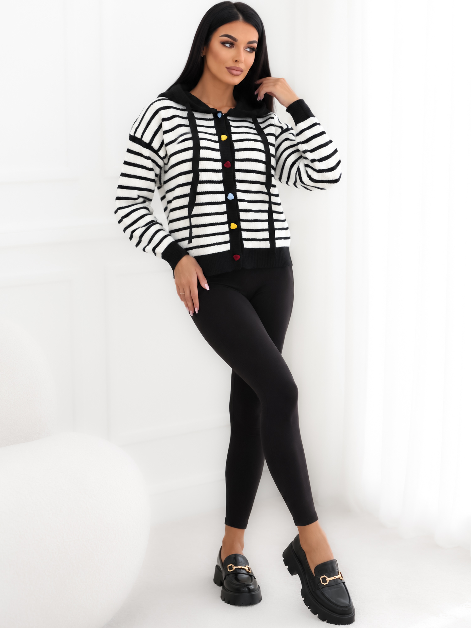 Schwarzer Cardigan mit gestreiftem Muster und bunten Herzen.