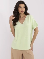 Pistazienfarbener Oversize-Pullover mit kurzen Ärmeln.