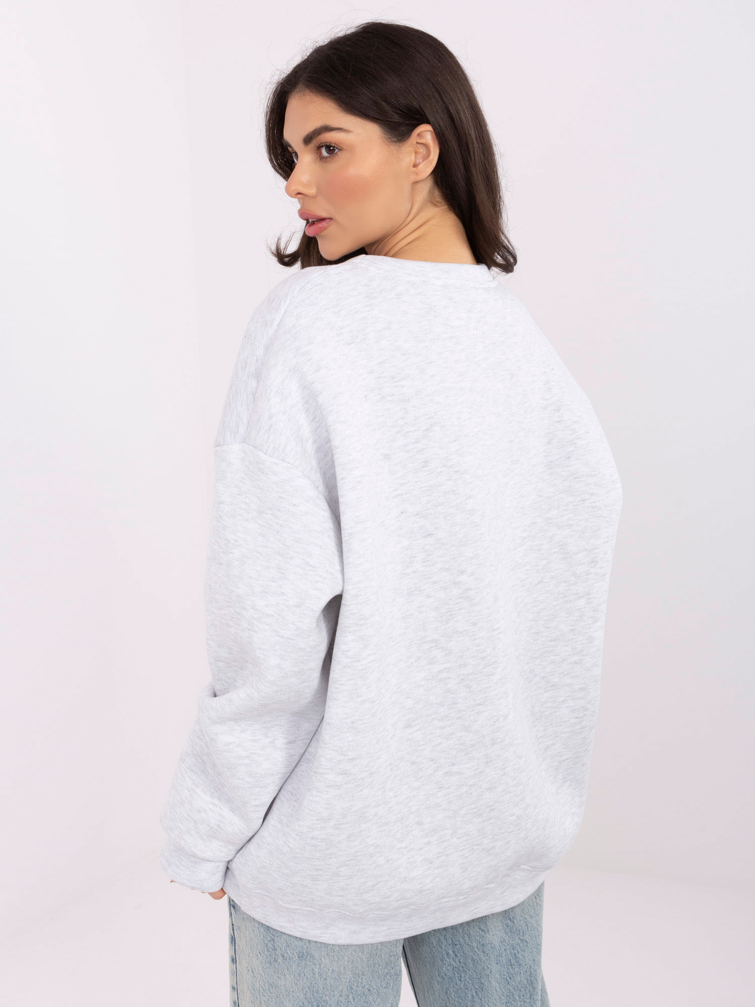 Světle šedá oversized mikina s vyšitým nápisem.
