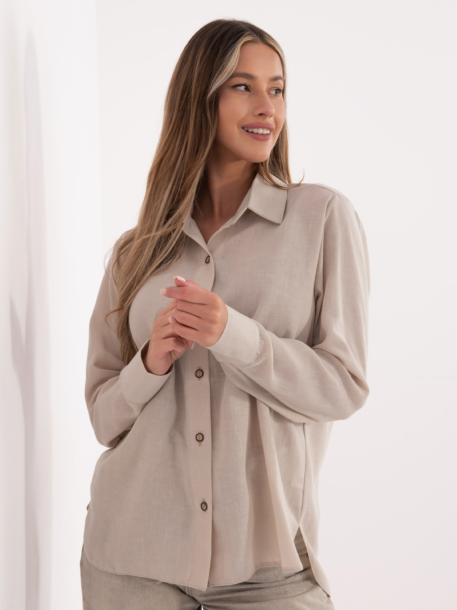 Beige Damenbluse mit längerem Rücken.