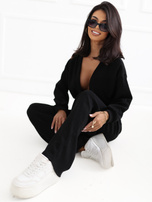 Schwarzes Cord-Set mit kurzer Strickjacke.