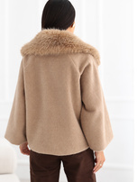 Beige trapeze coat with button closure.