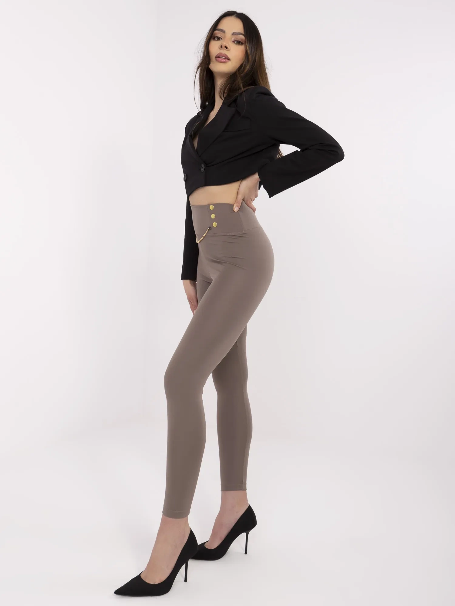 Kaffefarbene Damen-Leggings mit dekorativen Druckknöpfen.
