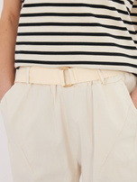 Light beige fabric trousers with a belt.