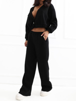 Schwarzes Cord-Set mit kurzer Strickjacke.