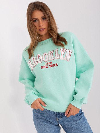 Moteriška mėtų spalvos be gobtuvo palaidinė su užrašu.
